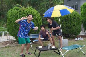 バーベキューを楽しみ、ピースサインをしている写真