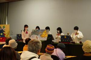 大型絵本の読み聞かせとそれに合わせた演奏をしている写真