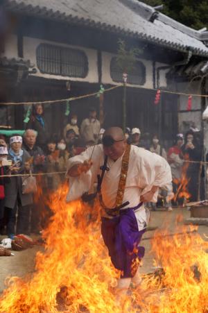 燃え盛る炎の中を駆け抜ける行者の写真